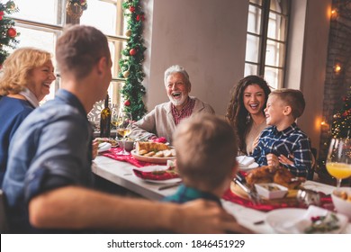 Beautiful happy family gathered around the table, having Christmas dinner, enjoying winter holiday season and their time together - Powered by Shutterstock