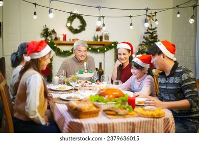 Beautiful happy family gathered around the table, having Christmas dinner, enjoying winter holiday season and their time together - Powered by Shutterstock