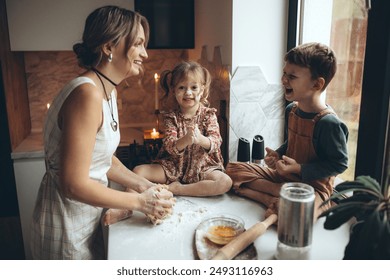 Beautiful and happy family in the kitchen. Mom and children prepare dough, bake cookies - Powered by Shutterstock