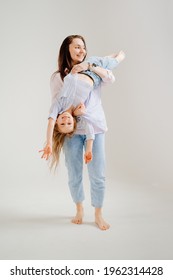 Beautiful Happy Family At A Photo Shoot In A White Photo Studio. Backstage. Mom And Daughter Play And Have Fun. Mother's Day