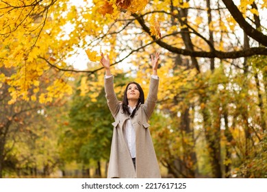 Beautiful Happy Female Office Worker Throws Orange, Yellow Leaves Up, Having Fun In Autumn Park During Lunch Time, Walking Outdoors. Relaxation, Enjoying,solitude With Nature. Stress Relief.Horizontal