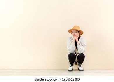 Beautiful Happy Girl In A Bright Cardigan And A Yellow Hat In Emotions Near The Yellow Wall. Place For Content