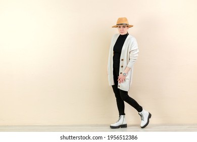 Beautiful Happy Girl In A Bright Cardigan And A Yellow Hat In Emotions Near The Yellow Wall. Place For Content