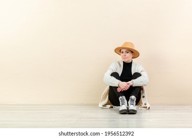 Beautiful Happy Girl In A Bright Cardigan And A Yellow Hat In Emotions Near The Yellow Wall. Place For Content