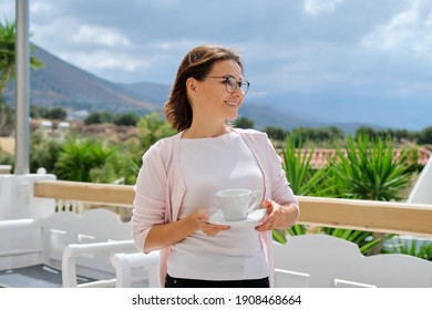 Beautiful Happy Mature Woman With Cup Of Coffee At Resort Hotel. Travel, Vacation, Tourism, Beauty, Nature, Middle-aged People