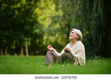 Beautiful Happy Old Woman Sitting In The Autumn Park