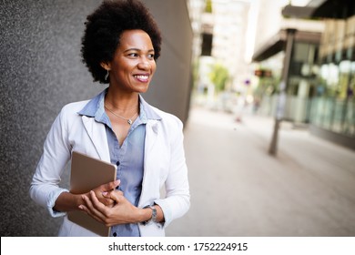 Beautiful happy professional business woman smiling happy with tablet outdoor - Powered by Shutterstock