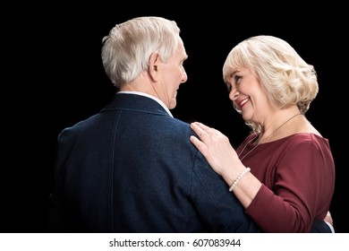 Beautiful Happy Senior Couple Dancing And Looking At Each Other  Isolated On Black 