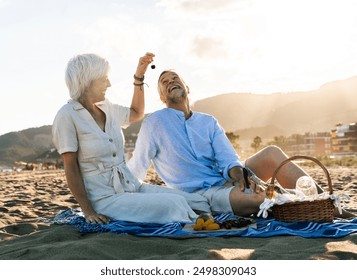 Beautiful happy senior couple dating at the seaside during summertime - Mature married couple in love bonding outdoors at the beach, concepts about elderly lifestyle, relationship and quality of life - Powered by Shutterstock