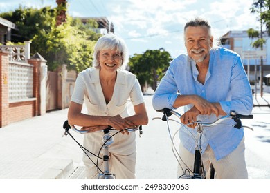 Beautiful happy senior couple dating at seaside in summertime - Mature married couple in love bonding outdoors and riding bicycle, concepts about elderly lifestyle, transportation and quality of life - Powered by Shutterstock