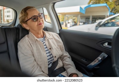 Beautiful happy senior woman in the passenger seat in the car enjoying the ride - Powered by Shutterstock