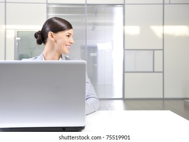 Beautiful Happy And Smiling Business Woman Working On Computer At Her Office And Looking Right From The Camera