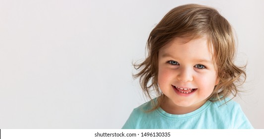 Beautiful happy toddler child girl smiling, portrait neutral background, space for text - Shutterstock ID 1496130335