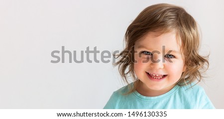 Beautiful happy toddler child girl smiling, portrait neutral background, space for text