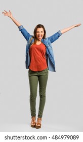 Beautiful Happy Woman With Arms Up Over A Gray Background