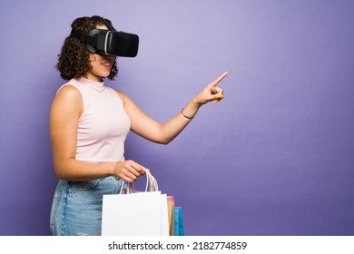Beautiful happy woman doing online shopping using virtual reality techonology during a modern simulation 