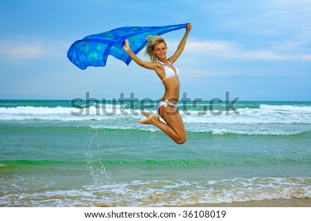 Beautiful happy woman enjoys freedom on tropical beach