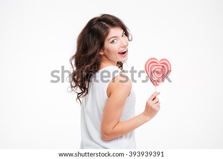 Beautiful happy woman holding lollipop and looking back at camera isolated on a white background