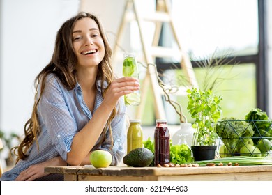 Beautiful Happy Woman Sitting With Drinks And Healthy Green Food At Home. Vegan Meal And Detox Concept