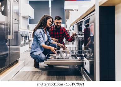 Beautiful and happy young couple buying dishwasher in modern appliances store. - Shutterstock ID 1531973891