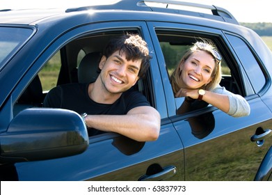 Beautiful Happy Young Couple Driving The Car