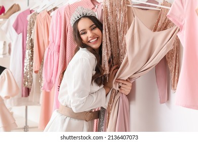 Beautiful happy young girl choosing clothes for high school prom in shop - Shutterstock ID 2136407073
