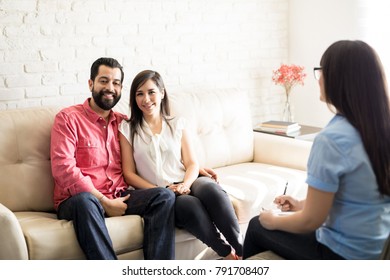 Beautiful And Happy Young Hispanic Couple Visiting Psychologist For Relationship Counseling