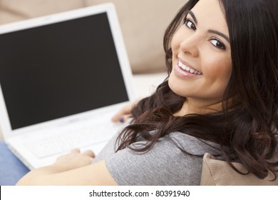 Beautiful Happy Young Latina Hispanic Woman Smiling And Using A Laptop Computer At Home On Her Sofa