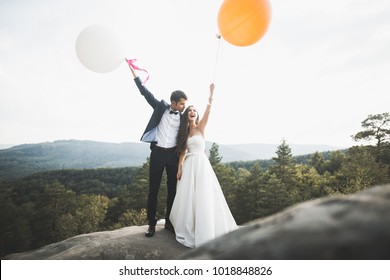 Beautiful Happy Young Wedding Couple Posing On A Background Of Rock Cliff