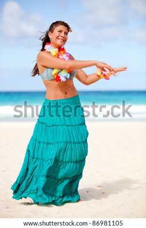 Beautiful Hawaiian woman dancing hula at the beach