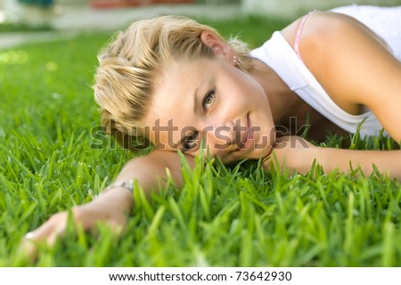 Beautiful healthy Young Woman relaxing on the green grass