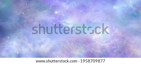 Beautiful heavens above celestial concept background banner - beautiful blue pink purple green lilac light filled heavenly ethereal cloud scape depicting the heavens above 

