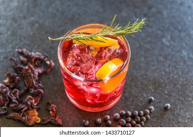 Beautiful hibiscus kombucha cocktail with gin and vodka, decorated with rosemary branch.