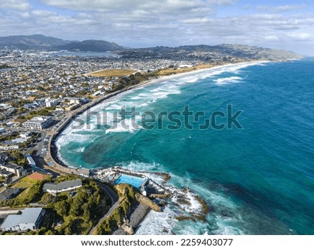 Beautiful high angle aerial drone view of a hot salt water pool in St Clair, a beachside suburb of Dunedin, the second-largest city in the South Island of New Zealand. Dunedin city in the background.