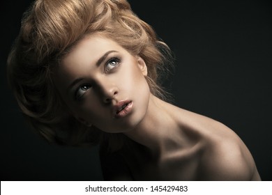 Beautiful High Fashion Female Model With Abstract Hair Style Behind The Table