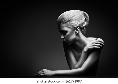 Beautiful High Fashion Female Model With Abstract Hair Style Behind The Table