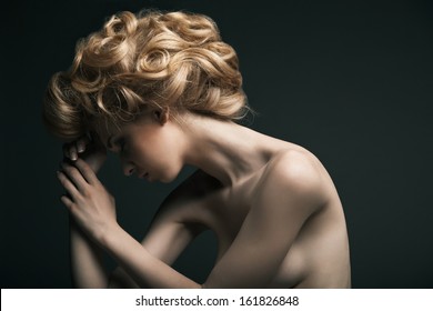 Beautiful High Fashion Female Model With Abstract Hair Style Behind The Table