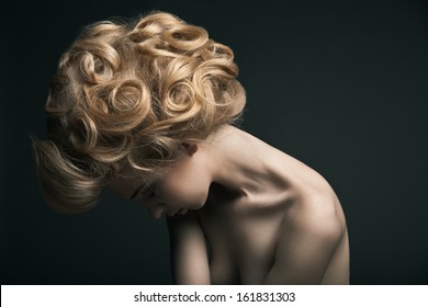 Beautiful High Fashion Female Model With Abstract Hair Style Behind The Table