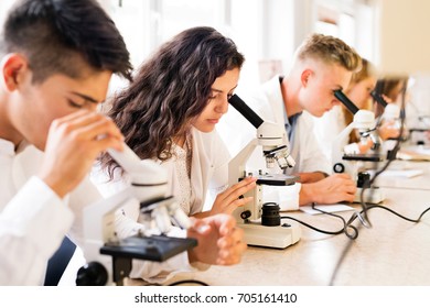 Beautiful high school students with microscopes in laboratory. - Powered by Shutterstock