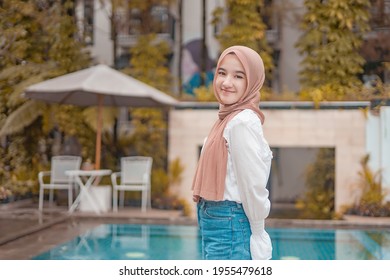
Beautiful hijab girl smiling sweetly near the swimming pool