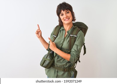 Beautiful Hiker Woman Wearing Backpack And Water Canteen Over Isolated White Background Smiling And Looking At The Camera Pointing With Two Hands And Fingers To The Side.