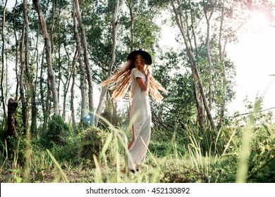 Beautiful hippie young woman in summer hat outdoors.