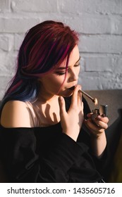 Beautiful Hipster Girl Lighting Up And Smoking Joint With Medical Marijuana