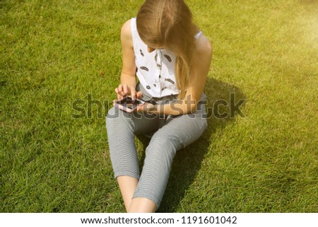 Similar – Woman with earphones listening music in smartphone