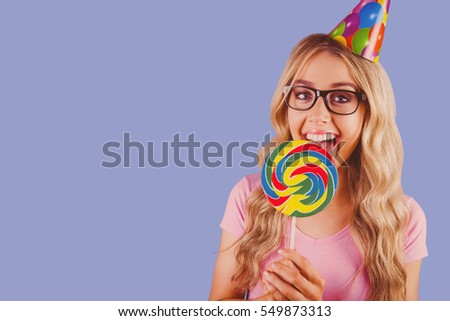 A beautiful hipster holding a giant lollipop against purple