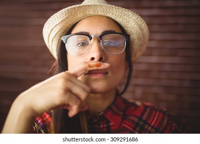 Beautiful Hipster With Mustache On Finger On Red Brick Background