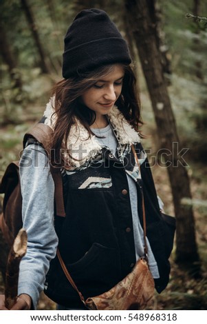 beautiful hipster traveler smiling, walking in woods. stylish woman hiking. wanderlust and travel concept 