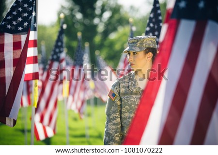Beautiful Hispanic American soldier in Uniform standing in front of American flags