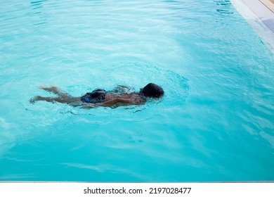 Beautiful Hispanic Boy Playing In An Outdoor Pool