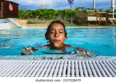 Beautiful Hispanic Boy Playing In An Outdoor Pool